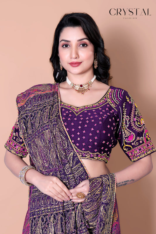 Woman wearing a purple saree ( sari ) with intricate patterns on a beige background.